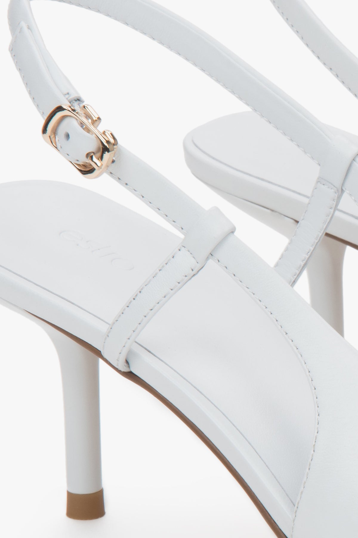 Białe czółenka damskie Estro, z odkrytą piętą, typu slingback, na stabilnej szpilce.