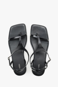 Z kwadratowym noskiem i paskiem między palcami, czarne płaskie sandały damskie Estro.