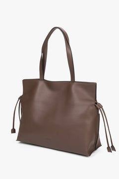Skórzana torba shopper o grubości 14 cm z widocznymi luźnymi rzemykami po bokach, ukazująca miękkość i szlachetną strukturę gładkiej skóry.