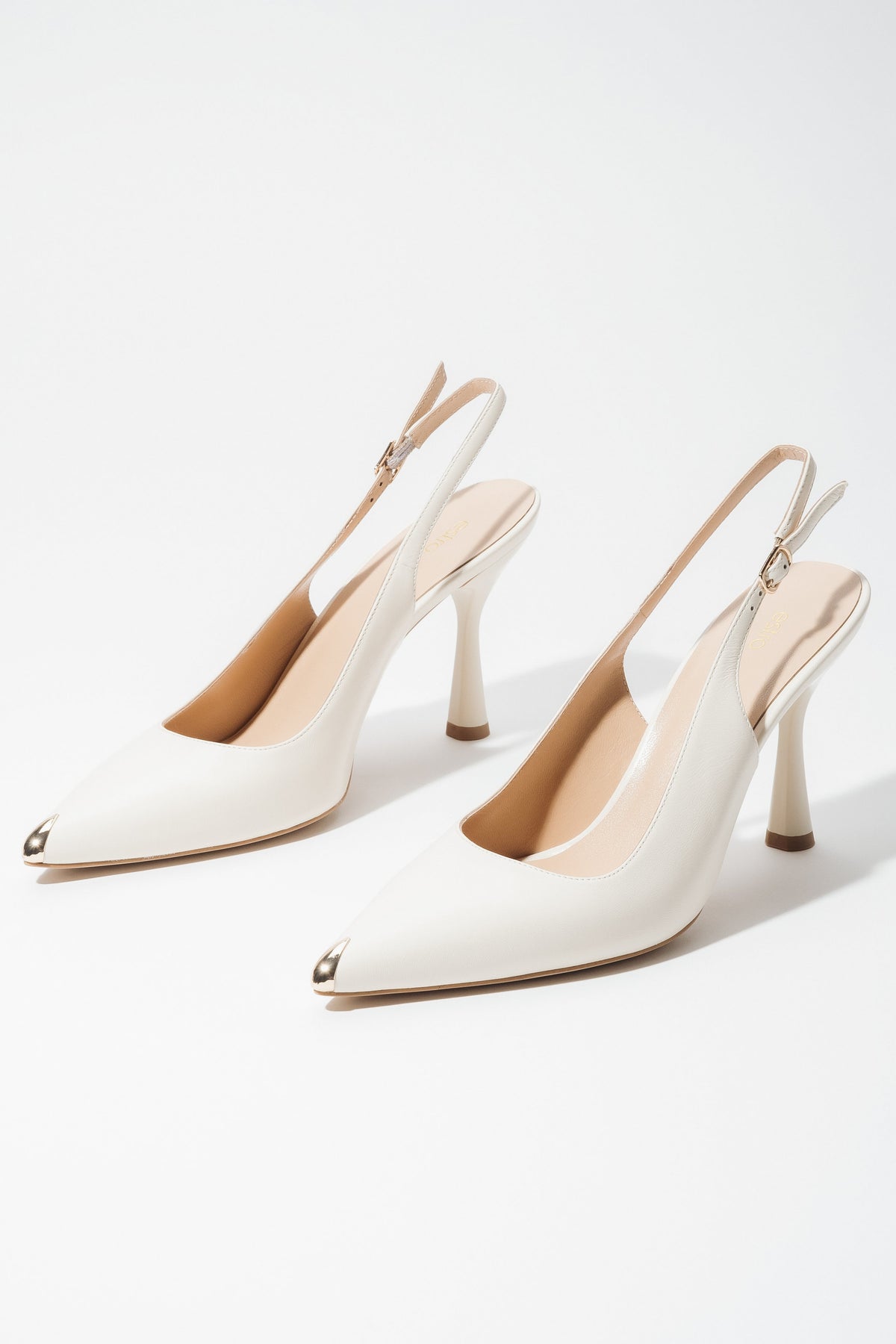 Jasnobeżowe skórzane czółenka damskie typu slingback na obcasie ze złotym czubkiem w szpic Estro ER00119582.