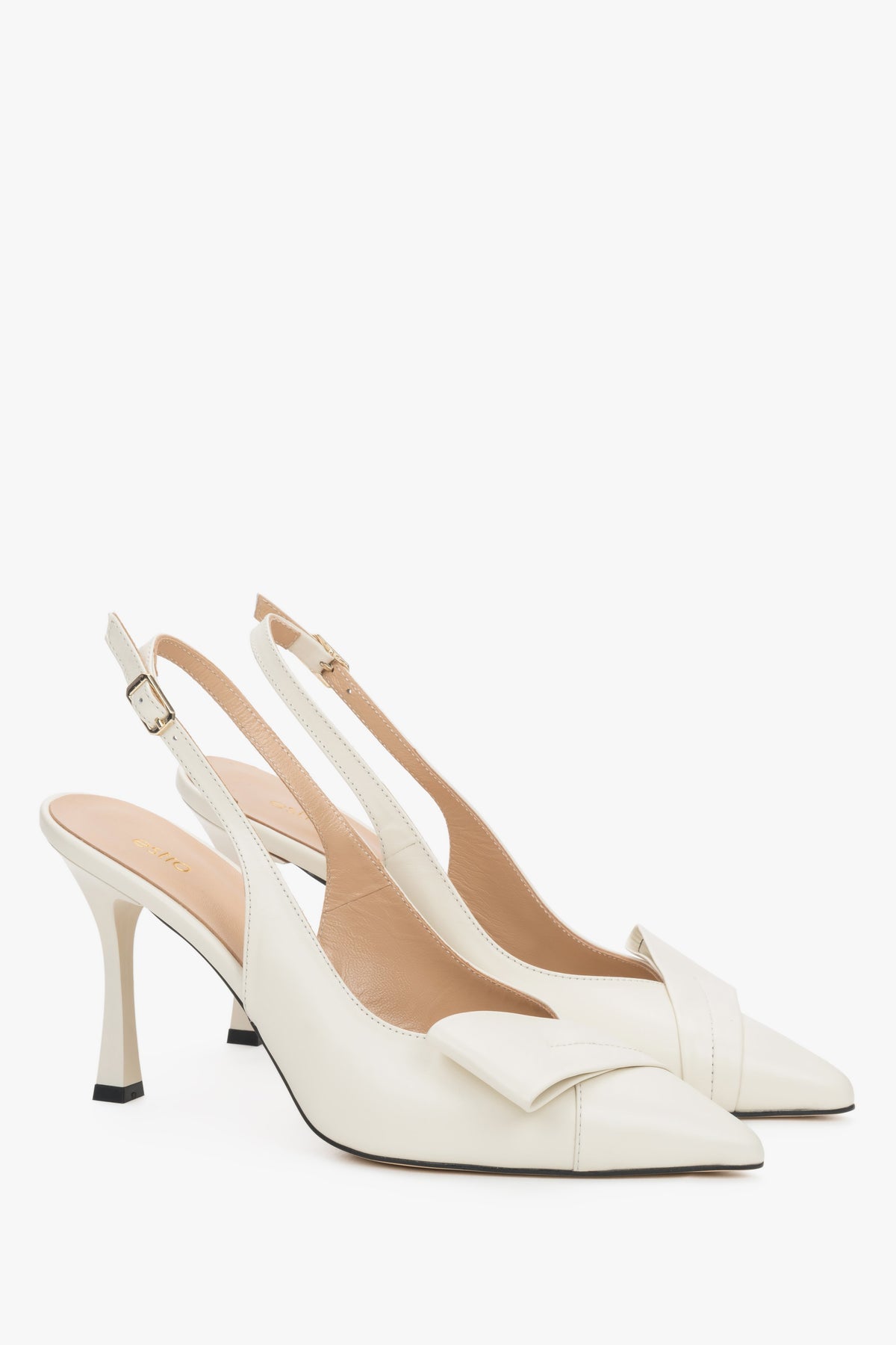 Jasnobeżowe skórzane czółenka slingback Estro na wysokiej szpilce, prezentujące głębokie wycięcie cholewki, geometryczny detal na nosku oraz wąski pasek wokół pięty.