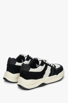 Sneakersy damskie ze skóry naturalnej i weluru - zbliżenie na zapiętek i przyszwę boczną butów w kolorze biało-czarnym.